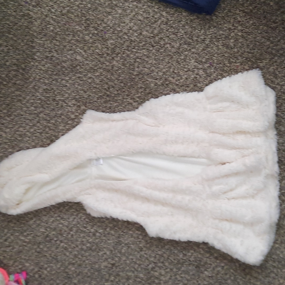 Fluffy cream colored vest .